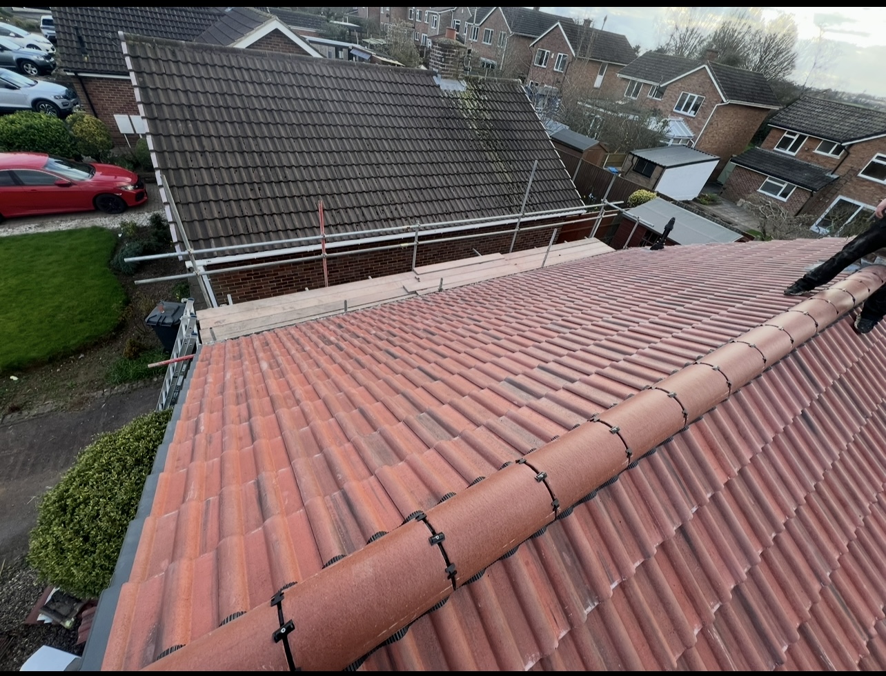 Red roof tiles and ridge detail from a First Choice Roofing project